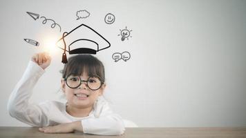 Happy Asian school kid graduate in graduation cap photo