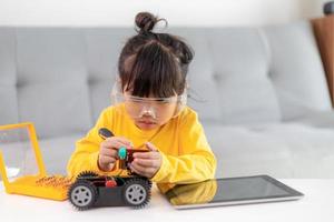Little girls having fun in a workshop coding robot car photo