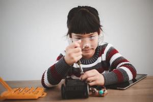 Asia students learn at home in coding robot cars and electronic board cables in STEM, STEAM, mathematics engineering science technology computer code in robotics for kids concept. photo