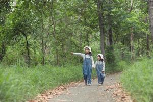 los niños se dirigen al campamento familiar en el paseo por el bosque a lo largo de la ruta turística. camino de acampada concepto de vacaciones de viaje familiar. foto