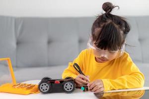 Asia students learn at home in coding robot cars and electronic board cables in STEM, STEAM, mathematics engineering science technology computer code in robotics for kids concept. photo