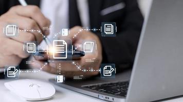 Businessman working with electronics document icons, E-document management, online documentation database, paperless office concept photo