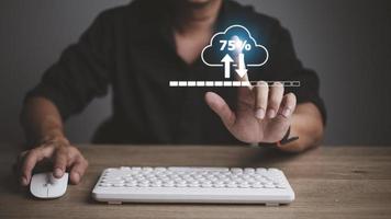 Man doing cloud uploading or downloading on laptop computer at office photo