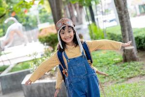 A cute little girl dressed in a cap and glasses of a pilot. The child dreams of becoming a pilot. photo