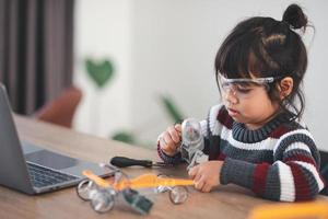 Inventive kid constructing robot cars at home photo