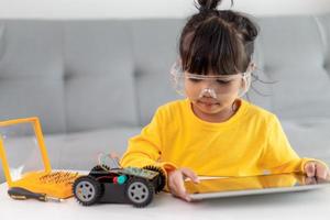 Little girls having fun in a workshop coding robot car photo