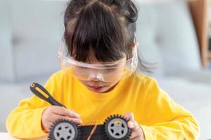 Little girls having fun in a workshop coding robot car photo