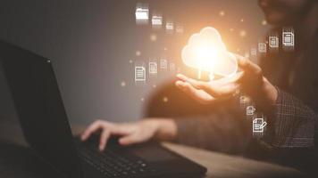 woman use Laptop with cloud computing diagram show on hand. Cloud technology. Data storage. Networking and internet service concept. photo