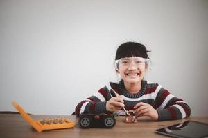 Inventive kid constructing robot cars at home photo