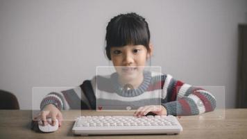 Asian girls use mouse and keyboard for streaming online, watching video on internet, live study, tutorial, online learning, education, home schooling. during Covid-19 pandemic lockdown. photo