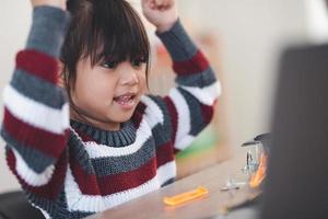 Inventive kid constructing robot cars at home photo