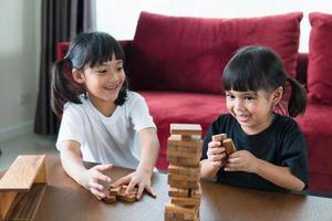 two Asian girl playing wooden stacks at home photo