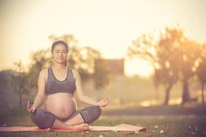 healthy pregnant woman doing yoga in nature outdoors.Vintage color photo
