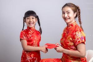 happy Asian little girl received red envelope from mother for Chinese new year photo