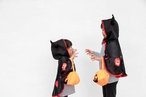 happy Halloween two children in Halloween costumes and with pumpkins on white background photo