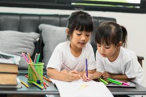 coronavirus covid-19 y aprendizaje desde el hogar, concepto de niño escolar en casa. los niños pequeños estudian en línea aprendiendo desde casa con una computadora portátil. foto