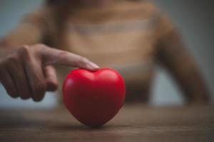 manos femeninas con corazón rojo, día mundial de la salud mental y día mundial del corazón, seguro de vida y salud, responsabilidad social rsc, foto