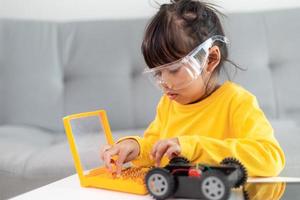 Little girls having fun in a workshop coding robot car photo