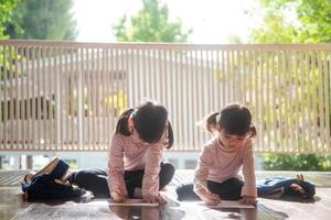 dos niños asiáticos haciendo la tarea juntos en casa foto