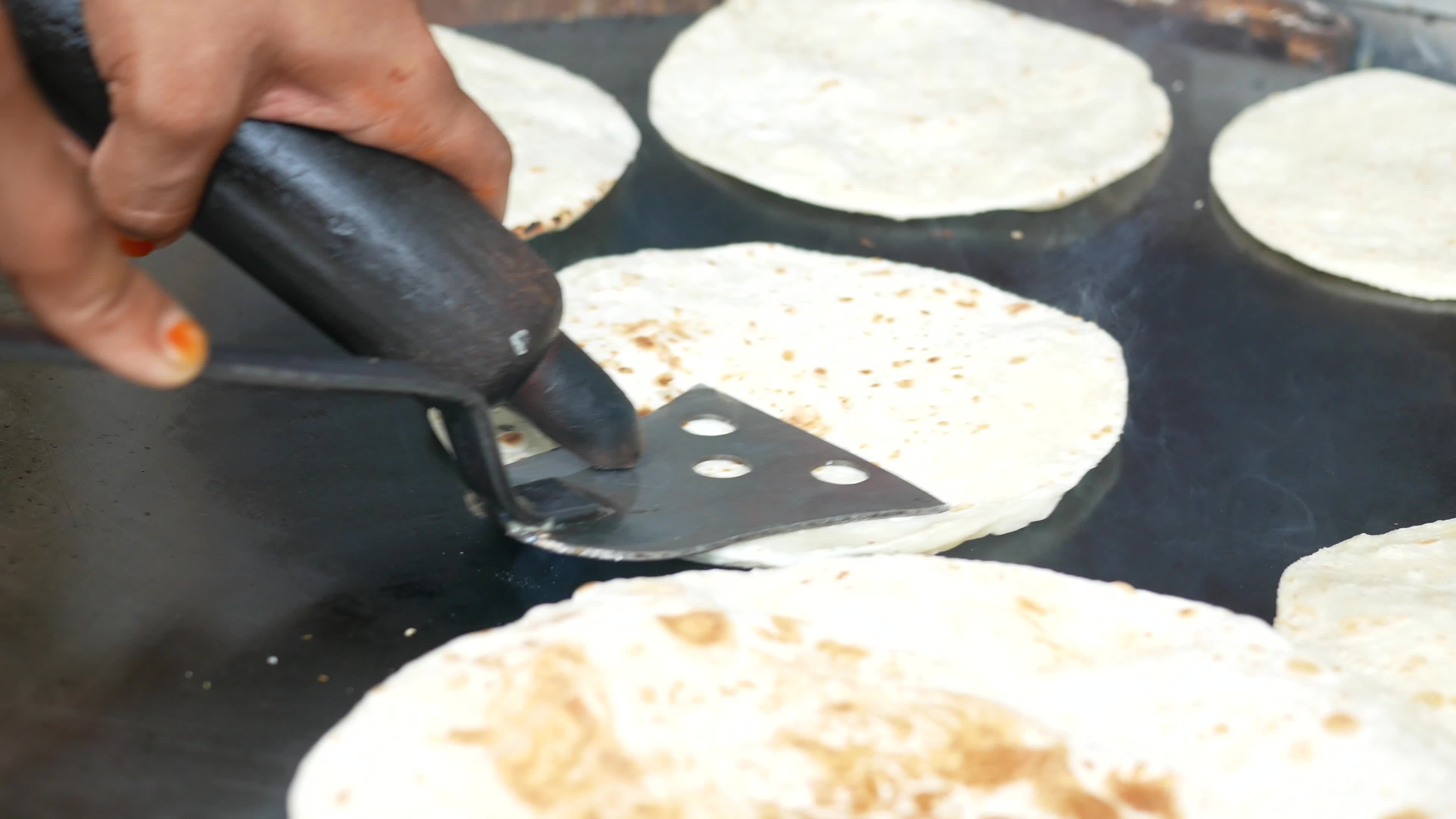 Tortillas cooked and flipped on large griddle 13064265 Stock Video at