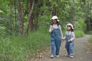 Children are heading to the family campsite in the forest Walk along the tourist route. Camping road. Family travel vacation concept. photo