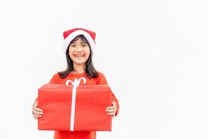 Happy Asian child in Santa red hat holding Christmas presents. Christmas time.on white background. photo