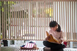 Cute Asian Girl Reading a Book at Home photo