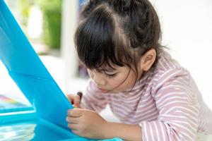 Little kids drawing with a colored pencil is a good activity for improving creative art and handwriting skills in children. Concept picture for education and learning hobby. photo