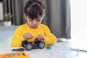 Asia students learn at home in coding robot cars and electronic board cables in STEM, STEAM, mathematics engineering science technology computer code in robotics for kids concept. photo