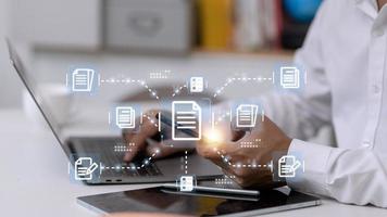 Businessman working with electronics document icons, E-document management, online documentation database, paperless office concept photo