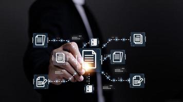 Businessman working with electronics document icons, E-document management, online documentation database, paperless office concept photo