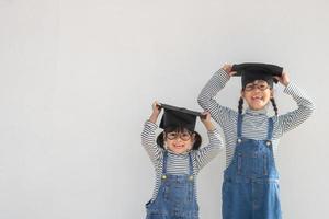 hermanos niños niña graduación con gorra foto
