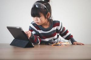 Inventive kid constructing robot cars at home photo