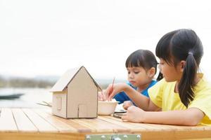 Asian sibling children drawing and painting colouring on the paper photo