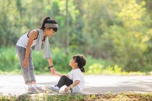 Cute asian girl give hand to help sister accident during running photo