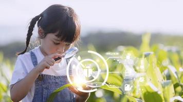 The little girl uses a tablet to analyze the growth of plants in the agricultural plot and visual icon., the agricultural technology concept. smart farming learning Concept photo