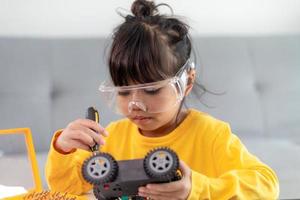 Asia students learn at home in coding robot cars and electronic board cables in STEM, STEAM, mathematics engineering science technology computer code in robotics for kids concept. photo