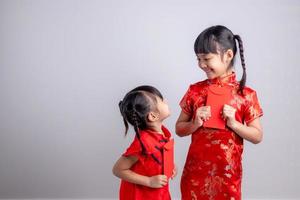 feliz Año Nuevo Chino. niñas asiáticas sonrientes que sostienen el sobre rojo foto