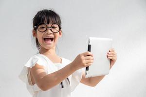 Shocked and surprised little girl on the internet with digital tablet computer concept for amazement, astonishment, making a mistake, stunned and speechless or seeing something he should not see photo