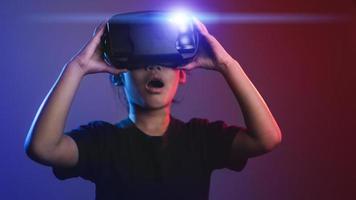 happy girl in glasses of virtual reality. Augmented reality, science, future technology concept. VR. Futuristic 3d glasses with virtual projection. Neon light. photo