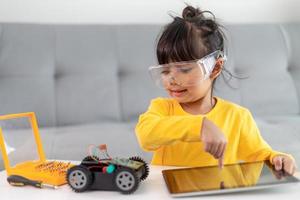 Little girls having fun in a workshop coding robot car photo