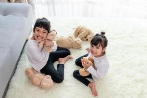 Cute funny children playing with teddy bear at home photo