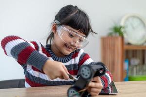 Asia students learn at home in coding robot cars and electronic board cables in STEM, STEAM, mathematics engineering science technology computer code in robotics for kids concept. photo