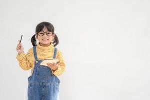 De vuelta a la escuela. una niña divertida con gafas de fondo blanco. niño de la escuela primaria con un libro. educación foto