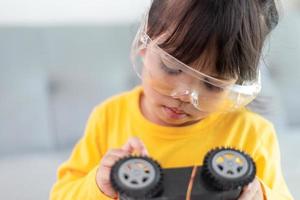 Asia students learn at home in coding robot cars and electronic board cables in STEM, STEAM, mathematics engineering science technology computer code in robotics for kids concept. photo