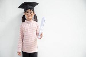 Happy Asian school kid graduate in graduation cap photo