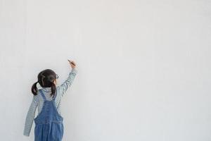 Little children painting on white wall photo