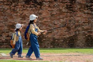 Two Asian children girls are bloggers. Broadcast on the Internet. Record vlog and blog subscribers. Record video lessons for Internet. Use camera with tripod. photo