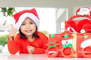 christmas, holidays and childhood concept - smiling girl with gift box at home photo