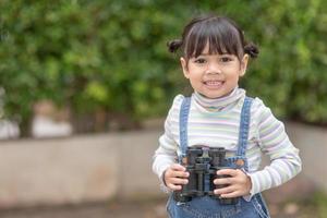 Happy kid looking ahead. Smiling child with the spyglass. Travel and adventure concept. Freedom, vacation photo